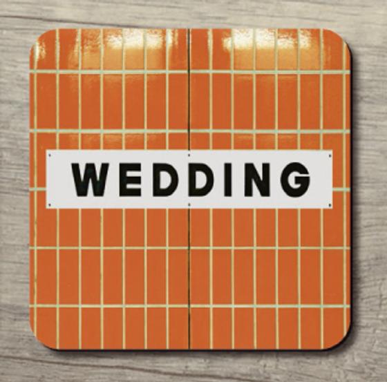 U-Bahnhof Wedding - schwarze Schrift auf weißem Schild auf orangenen Fliesen