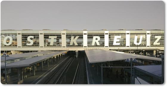 S-Bahnhof Ostkreuz - weiße Großbuchstaben über die Fenster des Bahnhofs verteilt, welche sich über den Schienen befinden
