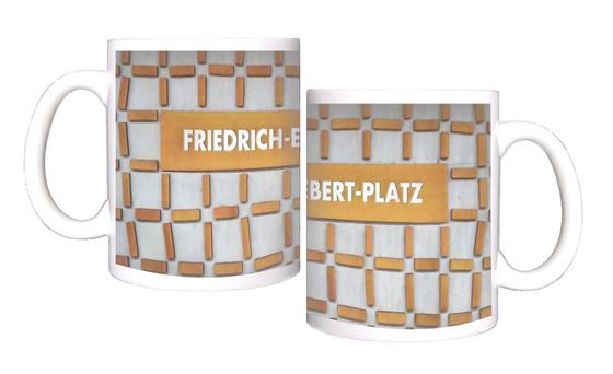 U-Bahn-Tasse Nuernberg Friedrich-Ebert-Platz der Linie U3 in der originalgetreuen Stations-Gestaltung - Hellblaugraue Wand mit rostig orangener Netzstruktur, Schild in gleicher Farbe mit weisser Schrift
