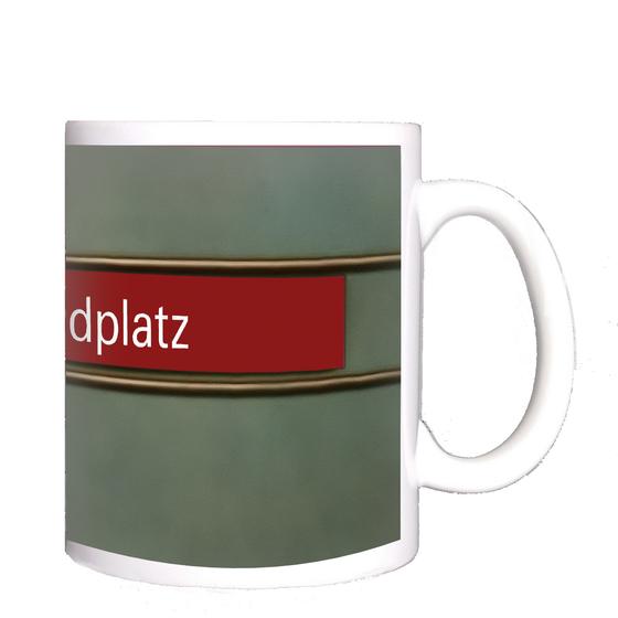 U-Bahnhof Candidplatz Kaffeetasse - weiße Schrift, auf rotem Streifen, schwarz umrandet, vor grauem Untergrund