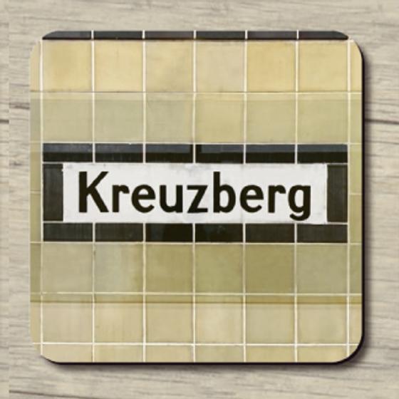 U-Bahnhof historisch Kreuzberg - schwarze Schrift auf weißem Schild mit schwarzer Umrahmung auf beigen Fliesen