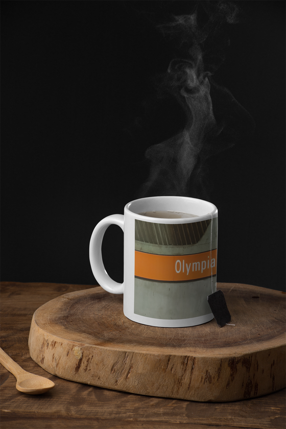 U-Bahnhof Olympiazentrum München Kaffeetasse - weiße Schrift auf orangem Schild vor grauer Betonwand