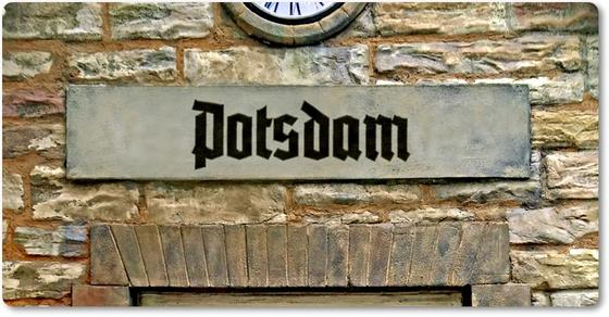 S-Bahnhof Potsdam Kühlschrankmagnet, schwarze Frakturschrift auf grauemhintergrund auf Backsteinwand über Torbogen