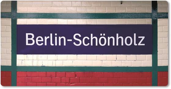 S-Bahnhof Schönholz Kühlschrankmagnet - weisse Fliesen, tannengrüne balkenartige Verstrebungen, die ein blaues Schild mit weisser Schrift einrahmen . Sockel aus kirschroten 
