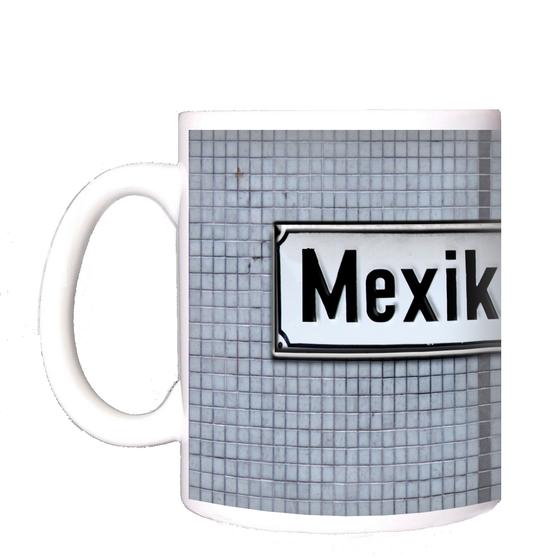 S-Bahnhof Mexikoplatz Kaffeetasse - schwarze Schrift auf weißem Metallschild, vor blauer Mosaikfliesenwand