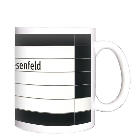 U-Bahnhof Oberwiesenfeld Kaffeetasse - schwarze Schrift auf weißem Untergrund, mit schwarzer Umrandung und grauen Querfugen