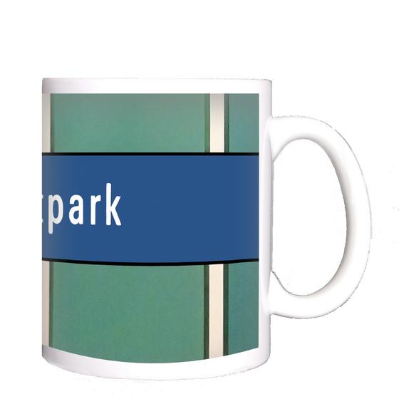 U-Bahnhof Westpark Kaffeetasse - weiße Schrift auf blauem Streifen, auf grün-türkiser Wand mit weißen Längsstreifen