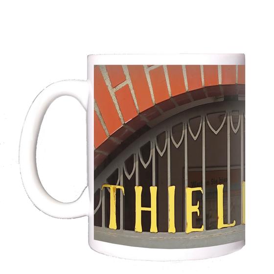 U-Bahnhof Thielplatz Kaffeetasse - goldene, extravagante Lettern