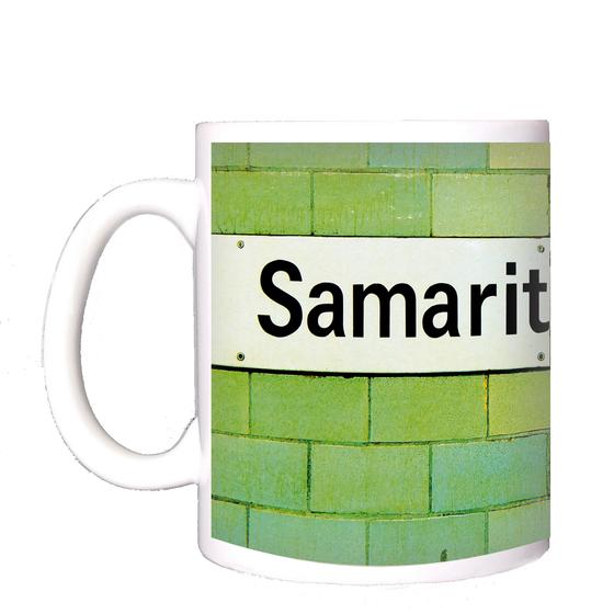 U-Bahnhof Samariterstraße Kaffeetasse - schwarzes Schild mit weißer Schrift auf grün-gelber Fliesenwand