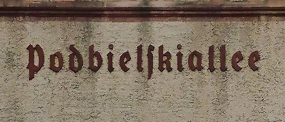 U-Bahnhof Podbielskiallee Kaffeetasse - schwarze, gebrochene Schrift auf grauer Betonwand