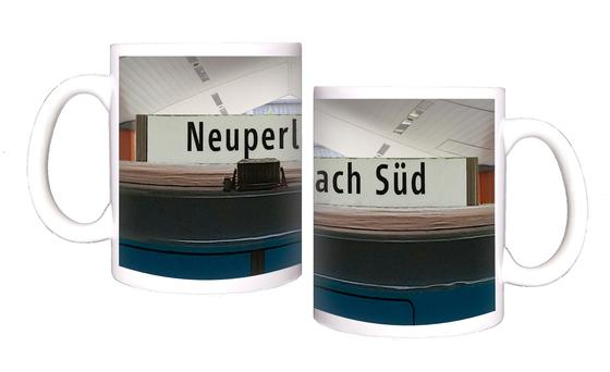 U-Bahnhof Neuperlach Süd Kaffeetasse - schwarze Schrift auf weißem Schild, in U-Bahnhof mit spitz zulaufender Decke