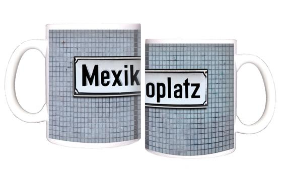 S-Bahnhof Mexikoplatz Kaffeetasse - schwarze Schrift auf weißem Metallschild, vor blauer Mosaikfliesenwand