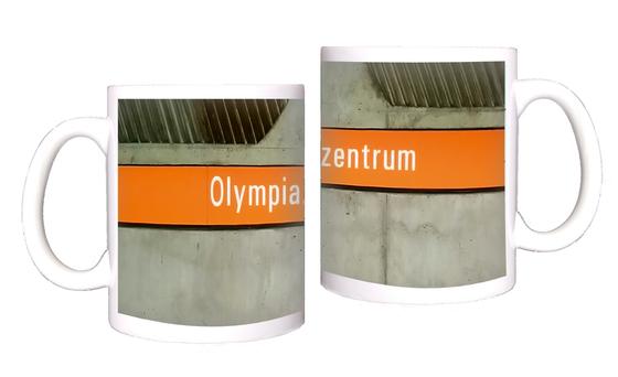 U-Bahnhof Olympiazentrum München Kaffeetasse - weiße Schrift auf orangem Schild vor grauer Betonwand