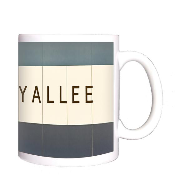 U-Bahn-Tasse Berlin - originalgetreue Stationsgestaltung, schwarze, schmale Schrift auf weißem Schild, vor blau-schwarzem Hintergrund