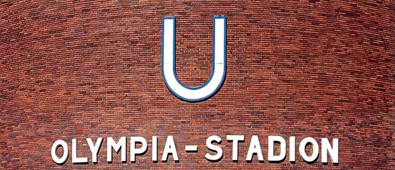 U-Bahnhof Olympia-Stadion Kaffeetasse - weißer Schriftzug unter weißem "U" auf rot-brauner Backsteinwand