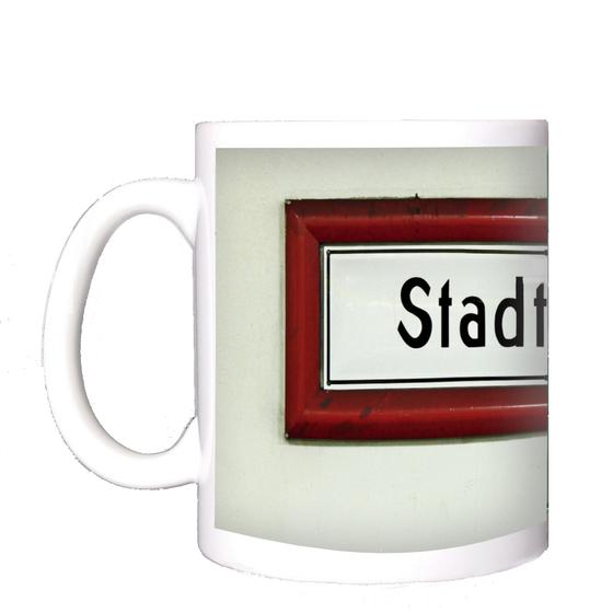 U-Bahnhof Stadtmitte Kaffeetasse - schwarze Schrift auf weißem Schild, mit rotem dickem Rahmen, vor weißer Wand