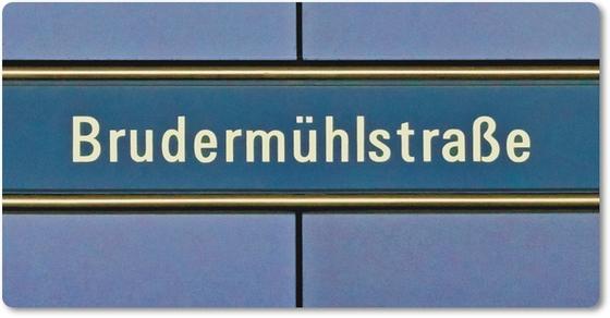 U-Bahnhof Brudermühlstraße Kühlschrankmagnet - weiße Schrift auf blauem Schild, gelb umrandet, vor fliederfarbenem Untergrund