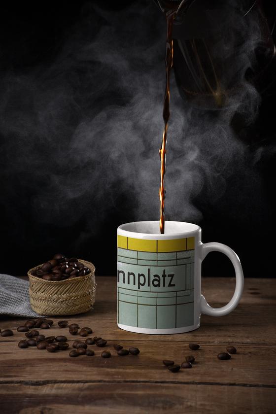Klassischer Kaffeebecher mit original Schriftzug und Kacheln des U-Bahnhof Hermannplatz in Berlin Neukoelln - schwarze Schift  petrol-grauen Kacheln