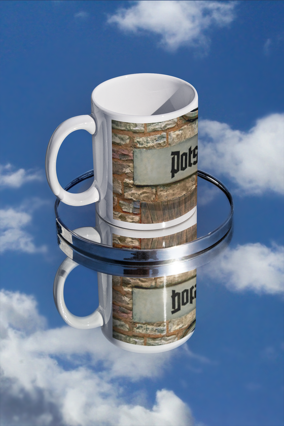 S-Bahnhof Potsdam Kaffetasse, schwarze Frakturschrift auf grauemhintergrund auf Backsteinwand über Torbogen