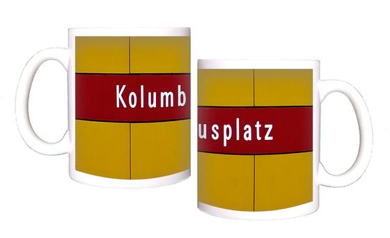 U-Bahnhof Kolumbusplatz Kaffeetasse - weiße Schrift auf dunkelrotem Streifen, vor gelber Plattenwand