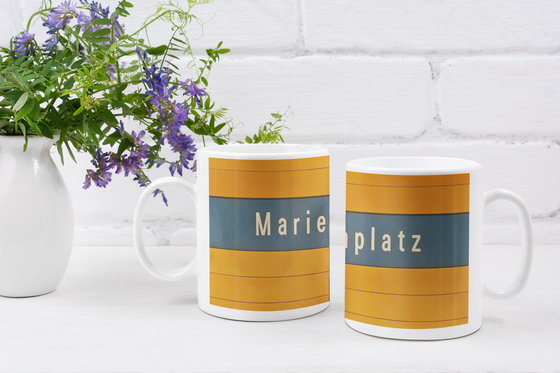U-Bahnhof Marienplatz Kaffeetasse - weiße Schrift auf blauem Schild, vor orangem Hintergrund