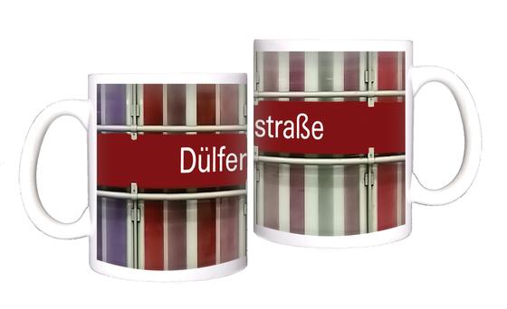 U-Bahnhof Dülferstraße Kaffeetasse - weiße Schrift auf rotem Schild auf Metallgestell, vor Streifenhintergrund in diversen Rottönen