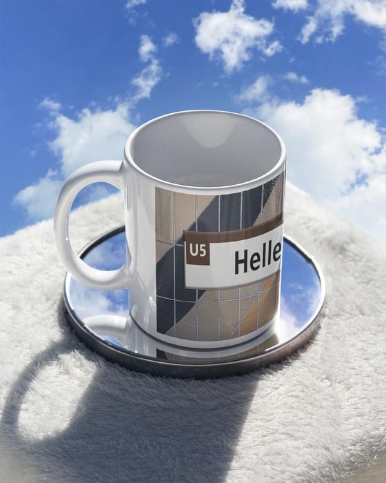 U-Bahn Kaffetasse Hellersdorf schwarze Schrift auf weißem Streifen über braun beige grau gestreiften Kacheln