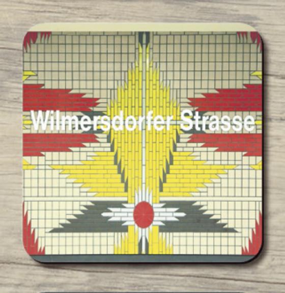 U-Bahnhof Wilmersdorfer Strasse - weiße Schrift auf Hintergrund aus Fliesen in beige, gelb, rot und grau