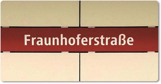 U-Bahnhof Fraunhoferstraße Kühlschrankmagnet- weiße Schrift, auf rotem Streifen vor weißer Plattenwand