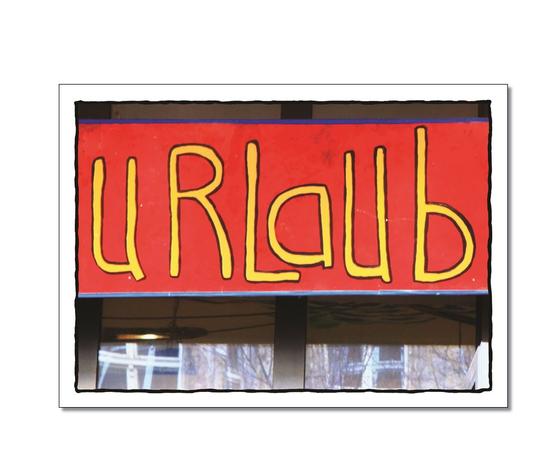 Klassische Postkarte - Frei. Vor einem Schaufenster heangt ein Schild mit der handgeschriebenen Aufschrift Urlaub. 