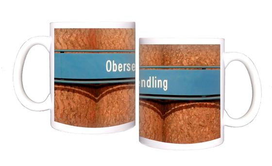 U-Bahnhof Obersendling Kaffeetasse - weiße Schrift auf blauem Schild, vor Betonsäulen-Wand