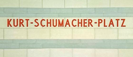 U-Bahnhof Kurt-Schumacher-Platz Kaffeetasse - rote Schrift auf weißen Kacheln mit hellblauen Querstreifen