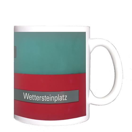 U-Bahnhof Wettersteinplatz Kaffeetasse - zwei graue Schild mit weißer Schrift,jeweils auf rotem und türkisem Untergrund