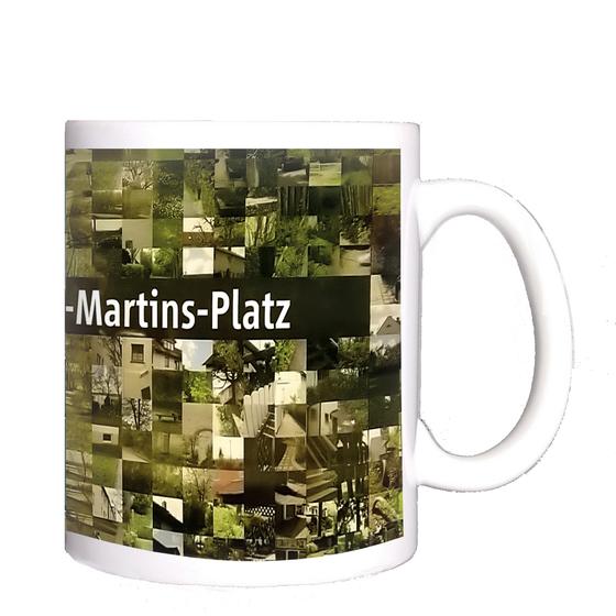 U-Bahnhof Moosacher St.Martins Platz Kaffeetasse - weiße Schrift auf schwarzem Streifen, vor Bildermosaik von der Umgebung