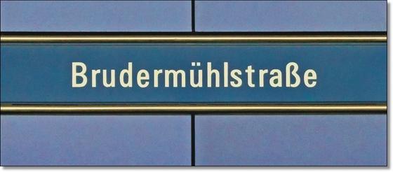 U-Bahnhof Brudermühlstraße Kaffeetasse - weiße Schrift auf blauem Schild, gelb umrandet, vor fliederfarbenem Untergrund