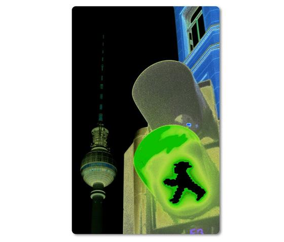 Foto eines typischen Berliner Ampelmanns und dem Berliner Fernsehturm bei Nacht. 
