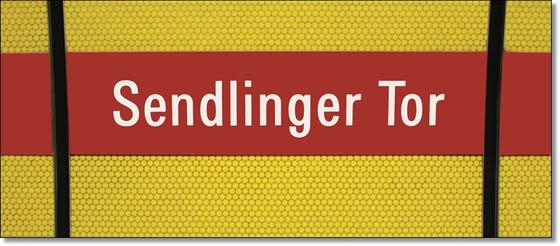 U-Bahnhof Sendlinger Tor Kaffeetasse - weiße Schrift auf rotem Streifen, vor gelbem Raster, durchzogen von schwarzem Senkrechtstreifen