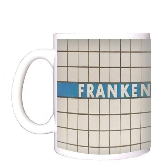 U-Bahn-Tasse Frankenstrasse der Nuernberger Linie U1 in der originalgetreuen Stations-Gestaltung - weiße Schrift auf blauem Streifen, Kachelhintergrund