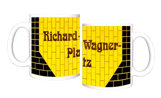 U-Bahnhof Richard-Wagner-Platz U-Bahn Souvenir Kaffeetasse - braune, verschlungene Schrift auf gelbem Kachelhintergrund, umrandet von schwarzen Kacheln