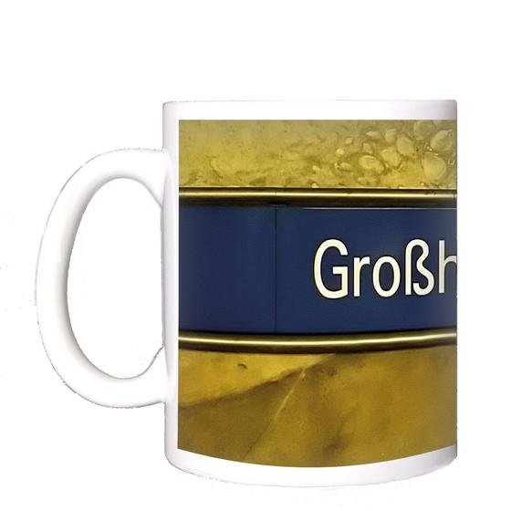 U-Bahnhof Großhadern Kaffeetasse - weiße Schrift auf dunkelblauem Streifen, vor gelber Wand mit Steinmuster