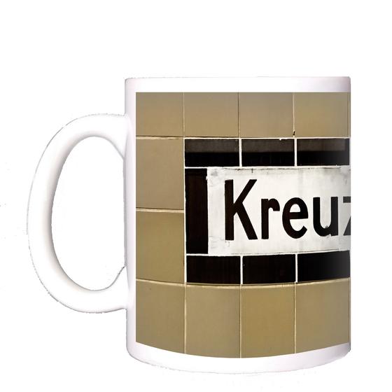 U-Bahnhof Kreuzberg - weißes Schild mit schwarzer Schrift und schwarzem Rand, vor beige-braunen Kacheln