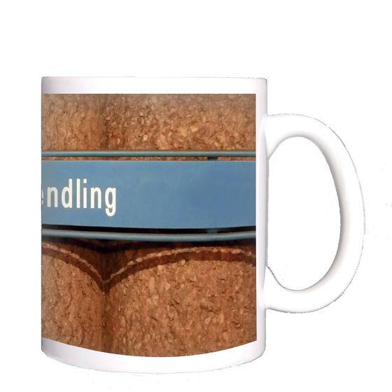 U-Bahnhof Obersendling Kaffeetasse - weiße Schrift auf blauem Schild, vor Betonsäulen-Wand