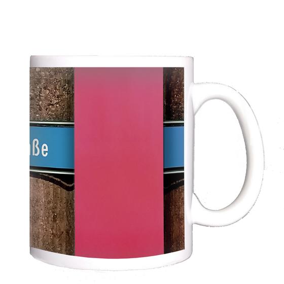 U-Bahnhof Machtlfinger Strasse Kaffeetasse - weiße Schrift auf blauem Schild, vor Betonsäulen-Wand mit pinkem Streifen
