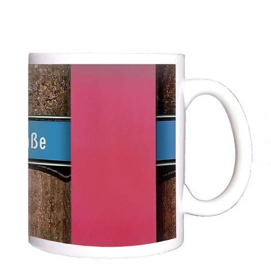 U-Bahnhof Machtlfinger Strasse Kaffeetasse - weiße Schrift auf blauem Schild, vor Betonsäulen-Wand mit pinkem Streifen