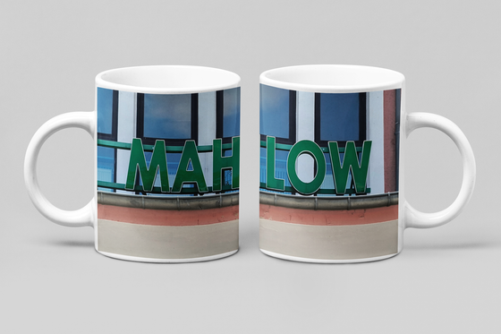 S-Bahnhof Mahlow Kaffeetasse grüne Schrift auf Bahnhofgebeude mit Fenstern dahinter