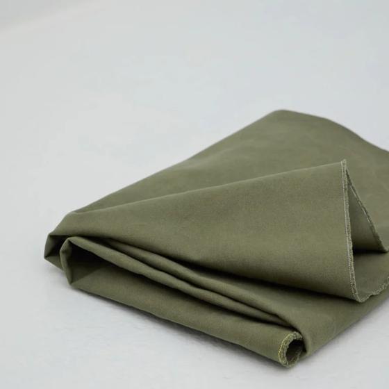 Schwerer gewaschener Canvas mit weicher Haptik und natürlicher Struktur für Taschen und Wohnaccessoires.