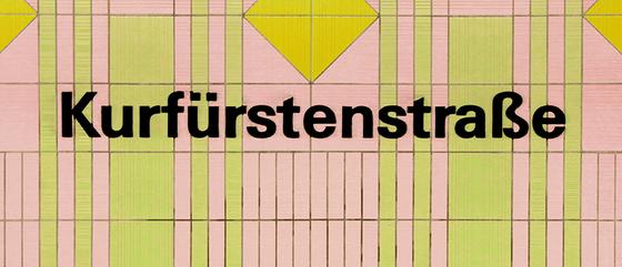 U-Bahnhof Kurfürstenstrasse Kaffeetasse - schwarzer Schrift auf rosa-grün gestreifter Kachelwand mit gelbem Quadrat