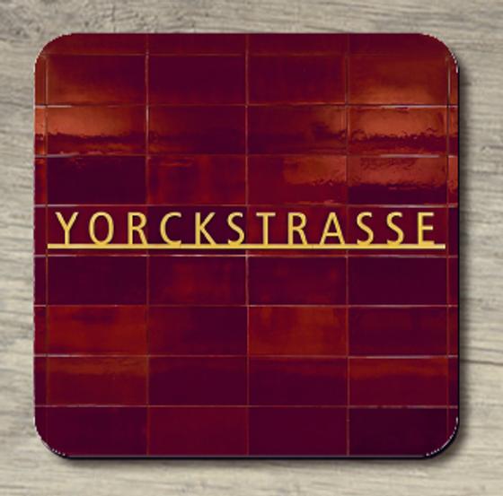 U-Bahnhof Yorckstrasse - goldene Buchstaben auf Fliesenhintergrund in unterschiedlich schillernden Dunkelrottönen