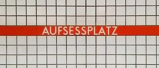U-Bahn-Tasse Aufsessplatz der Nuernberger Linie U1 in der originalgetreuen Stations-Gestaltung - weiße Schrift auf rot-orangem Streifen mit weißen Kachelhintergrund 