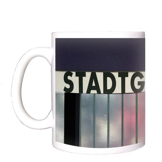 U-Bahn-Tasse Stadtgrenze in Fürth der Nuernberger Linie U1 in der originalgetreuen Stations-Gestaltung - oberirdische Drahtglaswand mit schwarzer Schrift auf weissem Schild - von aussen durchscheinende Lichtreflexe